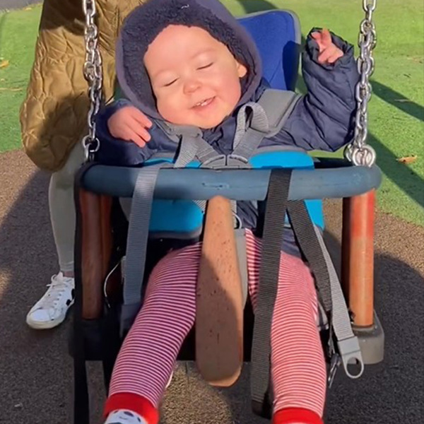 A child using the GoTo postural support seat in a swing