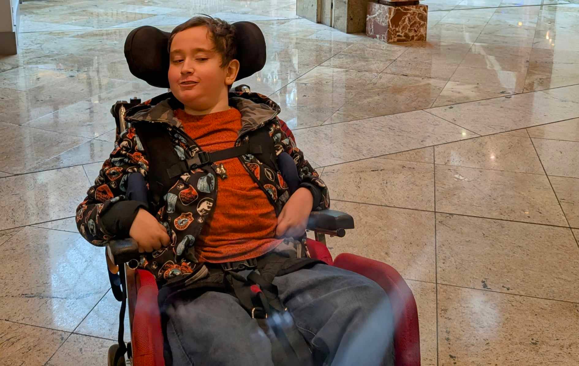 A happy young man sits in his wheelchair