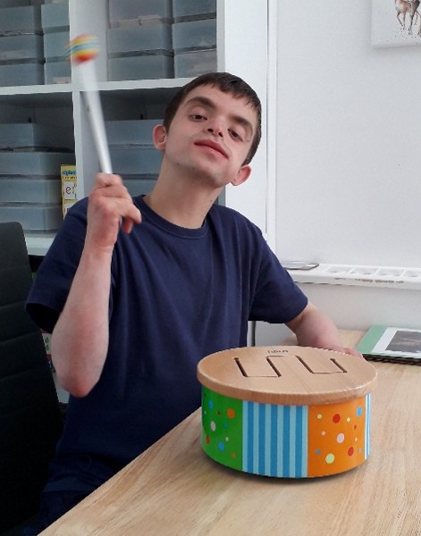 A young man plays a drum