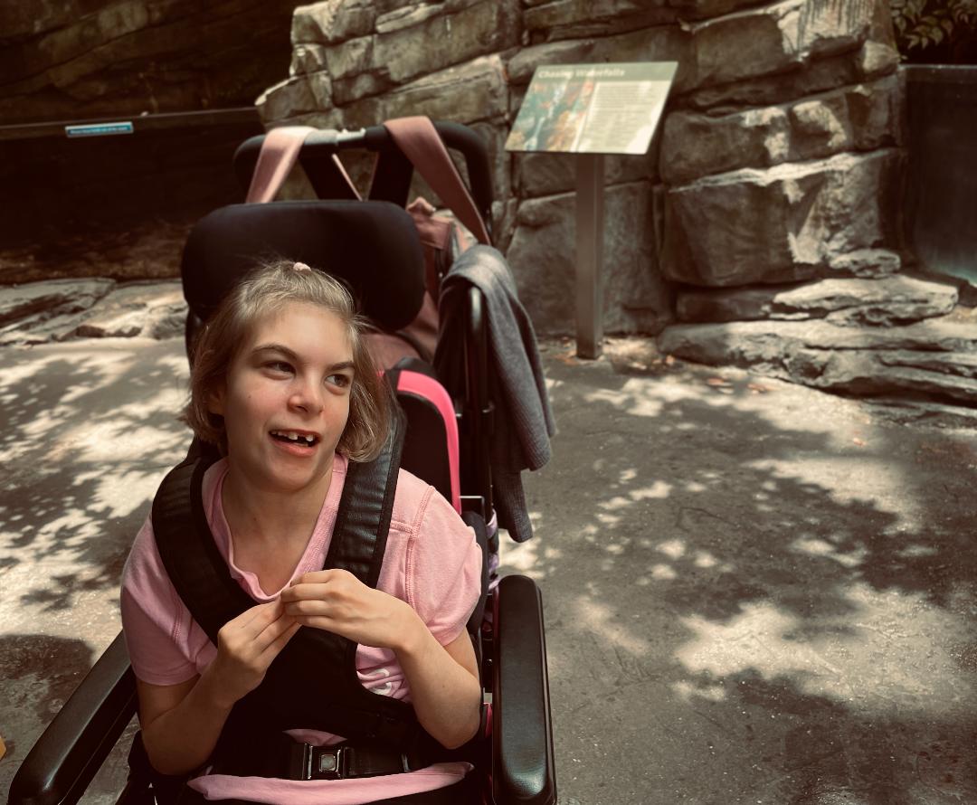A goung girl in a wheelchair on a day out