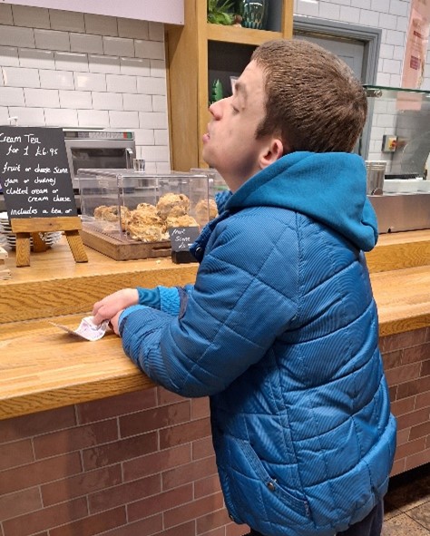 A young man waits at a cafe counter