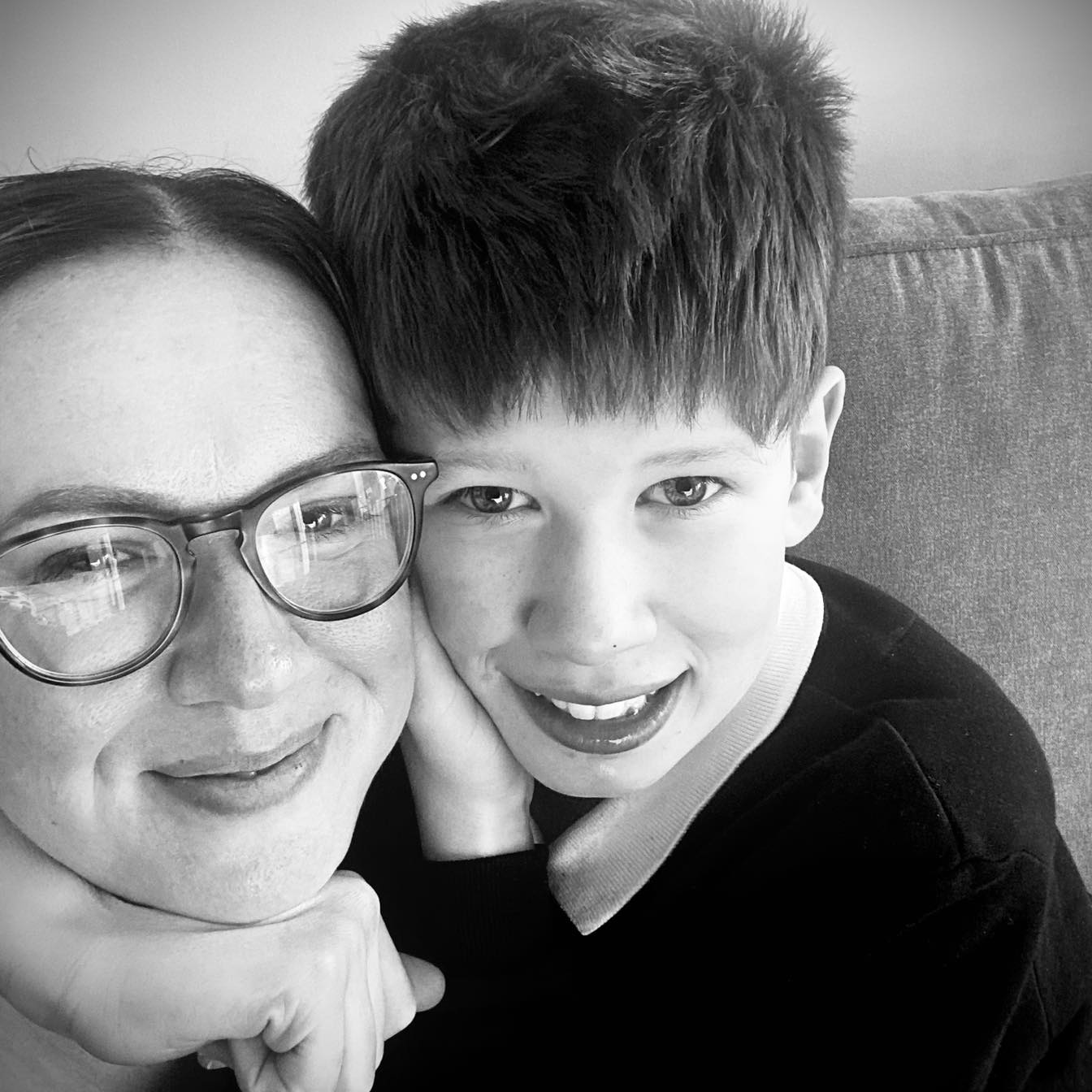 A mother and son smiling at the camera