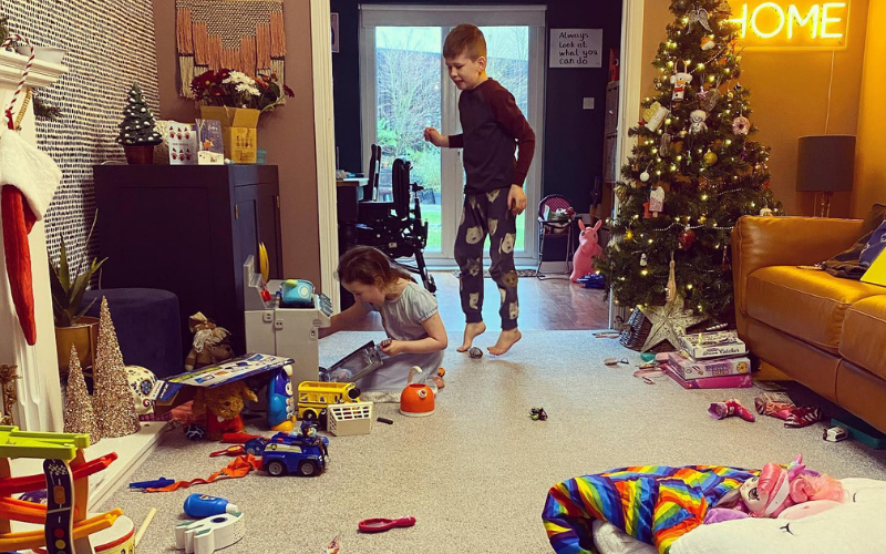 Two children looking at toys in a living room