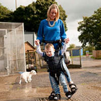 Child using Upsee product with parent to walk through the park.