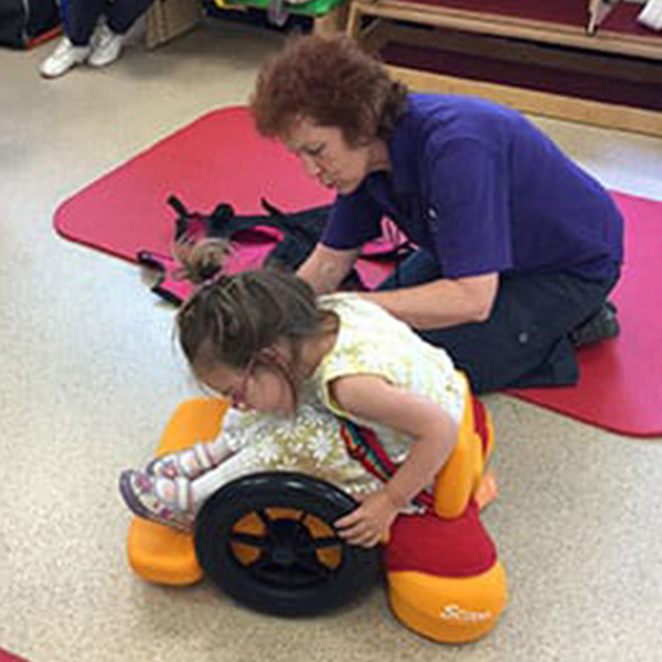 Un niño se inclina hacia delante en el Scooot sit and ride.