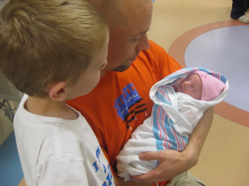 A brother admires his baby sister
