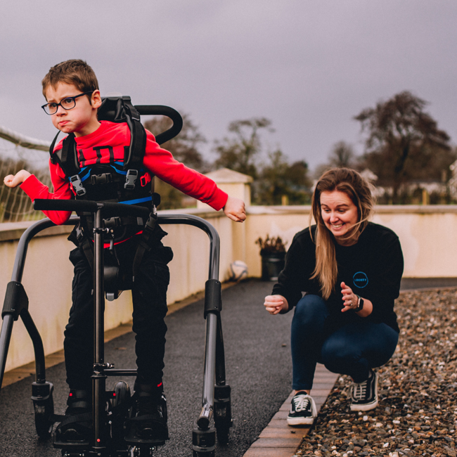 Image of therapist helping child walk using Firefly products