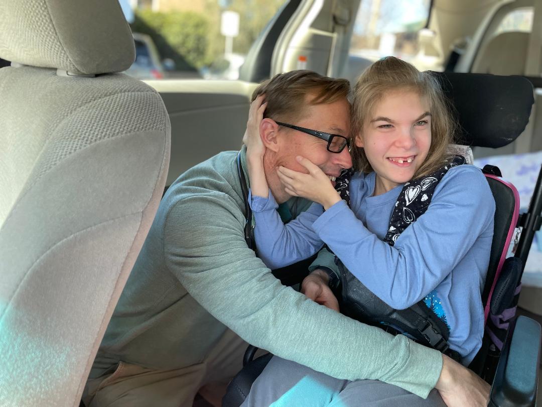 A young girl hugs her father