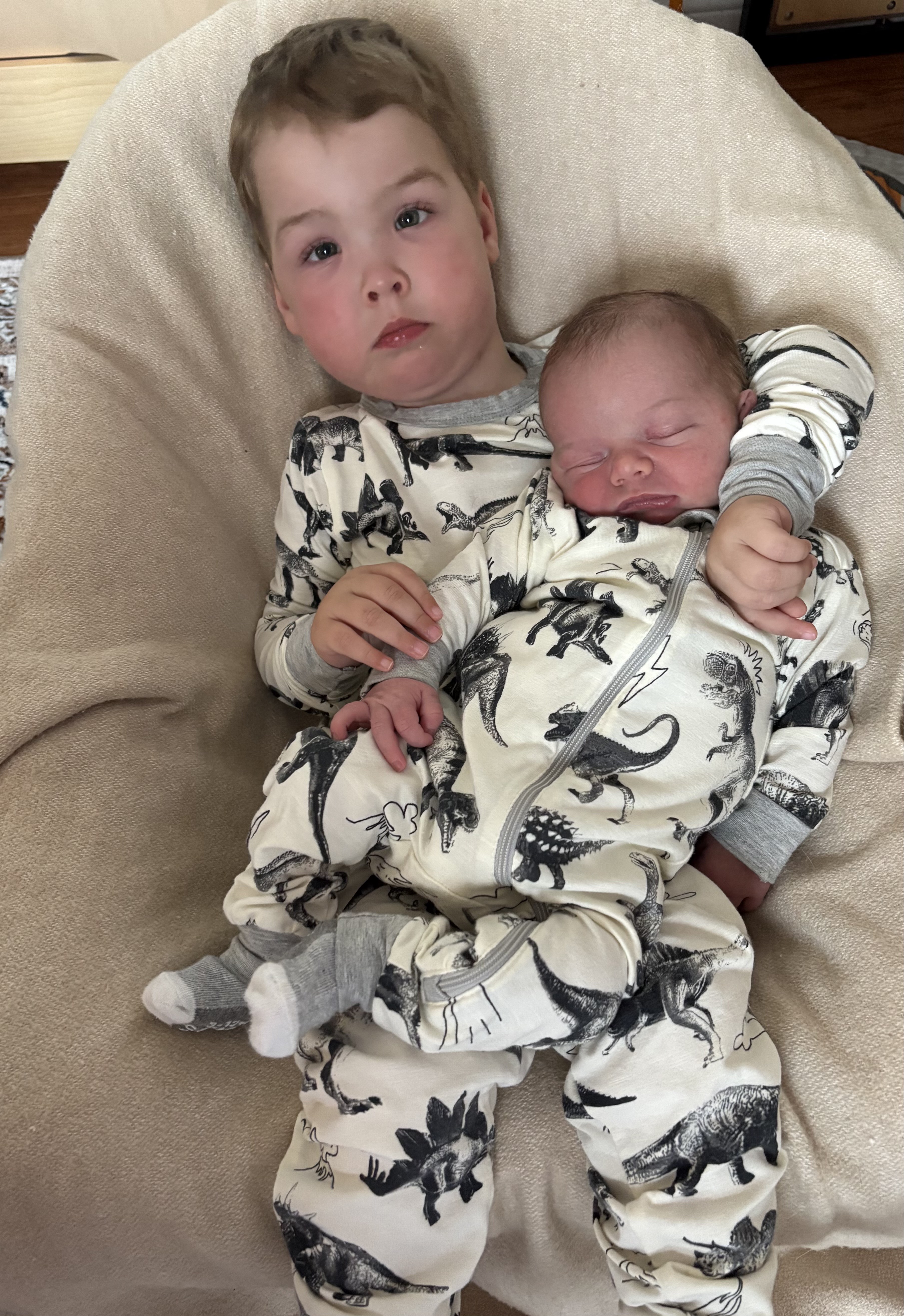 A little boy cuddling his baby brother