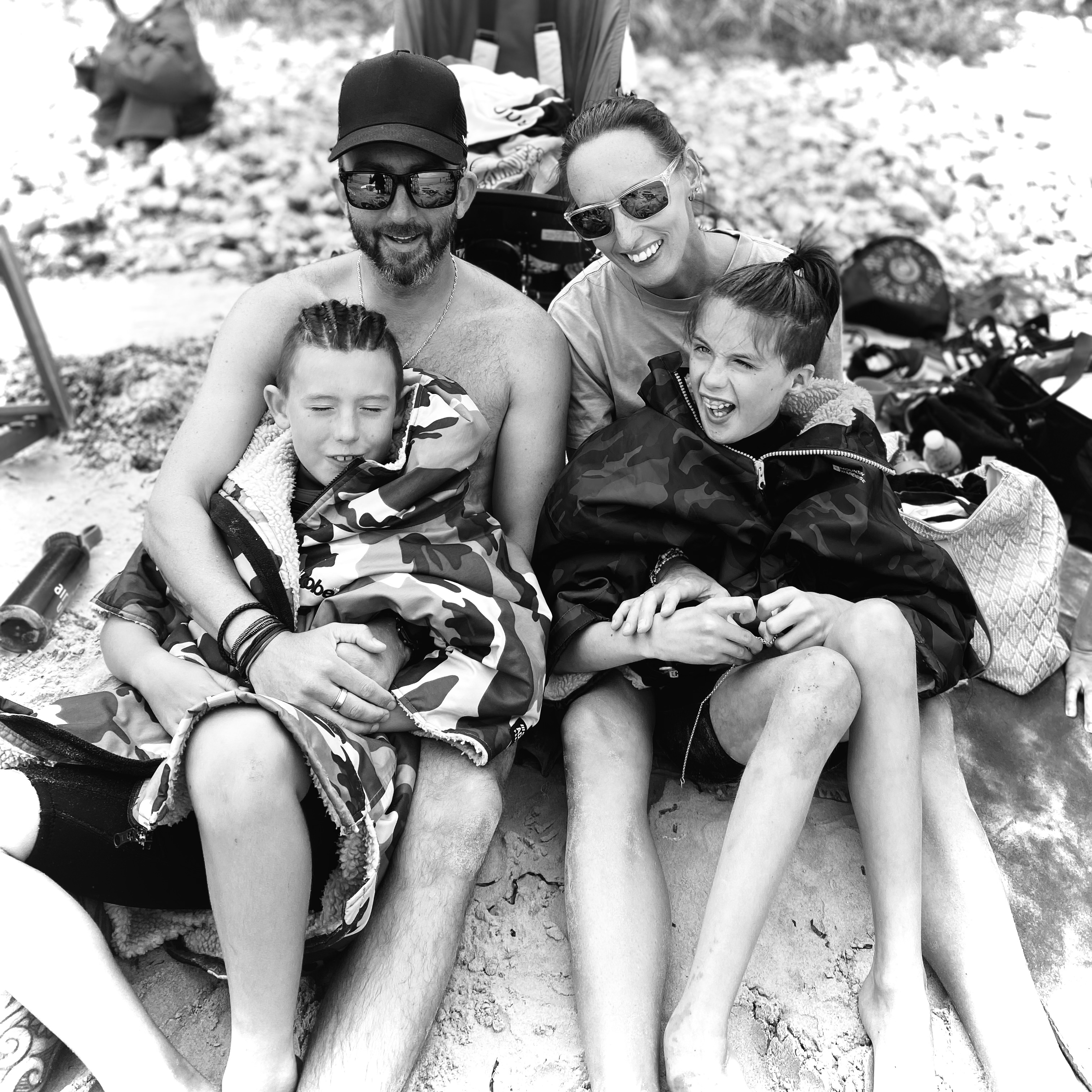 A family sit happily on the beach