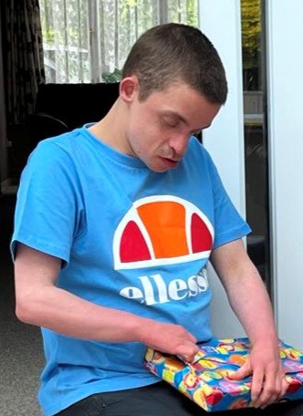 A young man opening a birthday present