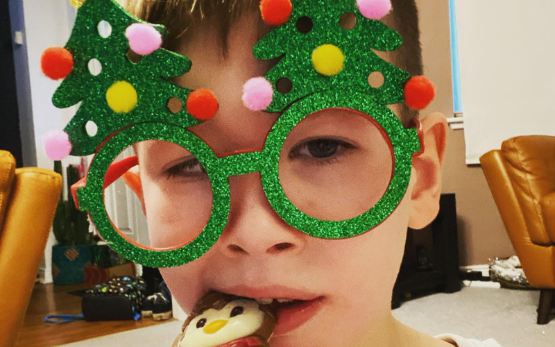 A child with green Christmas tree glasses