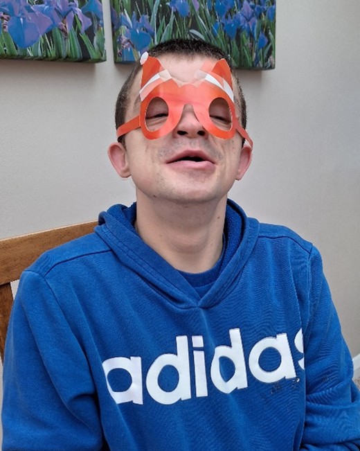 A young man wears a pair of party glasses