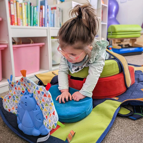 Imagen de Ivy, Reino Unido, utilizando activamente el Playpak en la posición más cómoda para ella.