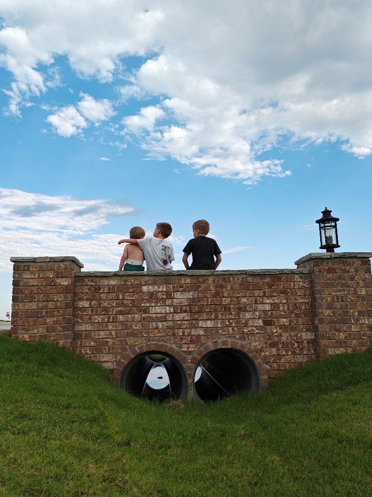 3 brothers sit on a wall together