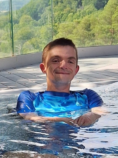 A young man swims in a pool on holiday