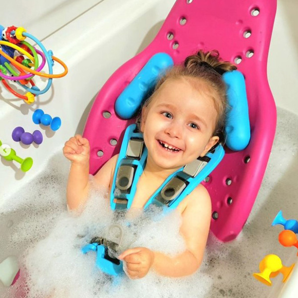 A little girl smiles while supported in her Splashy multipurpose bath seat.